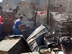A man salvages belongings from the charred remains his house, after a fire broke out in shanties at Gokulpuri area, in New Delhi.