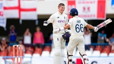 England's Zak Crawley celebrates with captain Joe Root after scoring a century against West Indies during day four of the first Test match at the Sir Vivian Richards Cricket Ground in North Sound, Antigua and Barbuda. (AP)