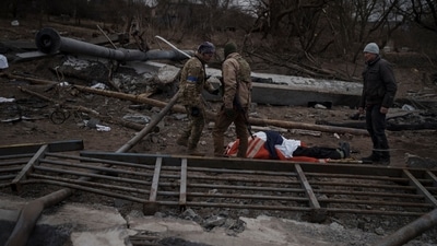 The body of a civilian, whose cause of death is unknown, lays on a stretcher on a path being used as an evacuation route out of Irpin, on the outskirts of Kyiv, Ukraine, Saturday. (AP) The body of a civilian, whose cause of death is unknown, lays on a stretcher on a path being used as an evacuation route out of Irpin, on the outskirts of Kyiv, Ukraine, Saturday. (AP)