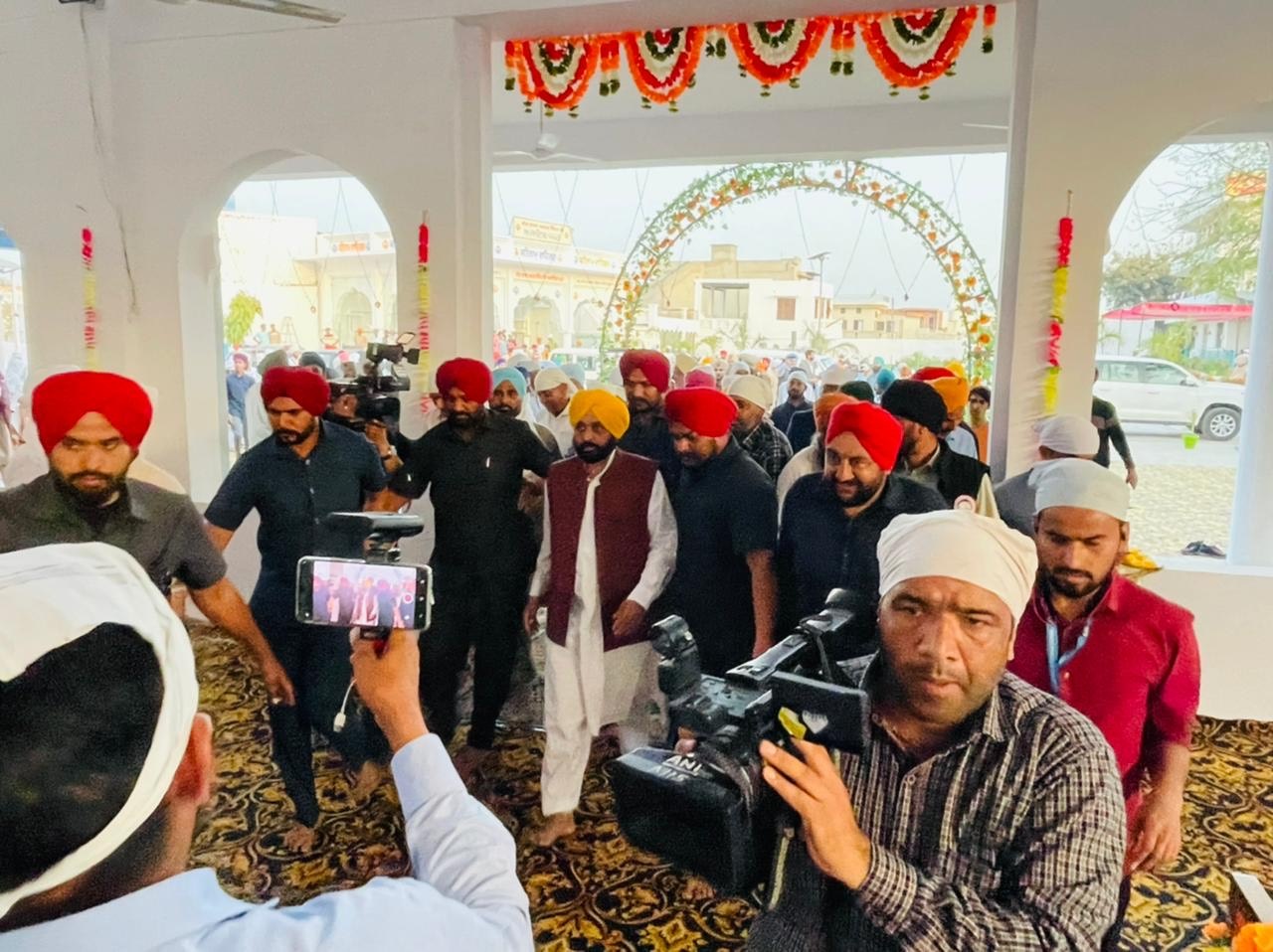 Punjab CM-designate Bhagwant Mann surrounded by the media as he reaches gurdwara Janam Asthan Cheema Sahib on Saturday to pay obeisance after AAP’s historic win in the state. (HT Photo)