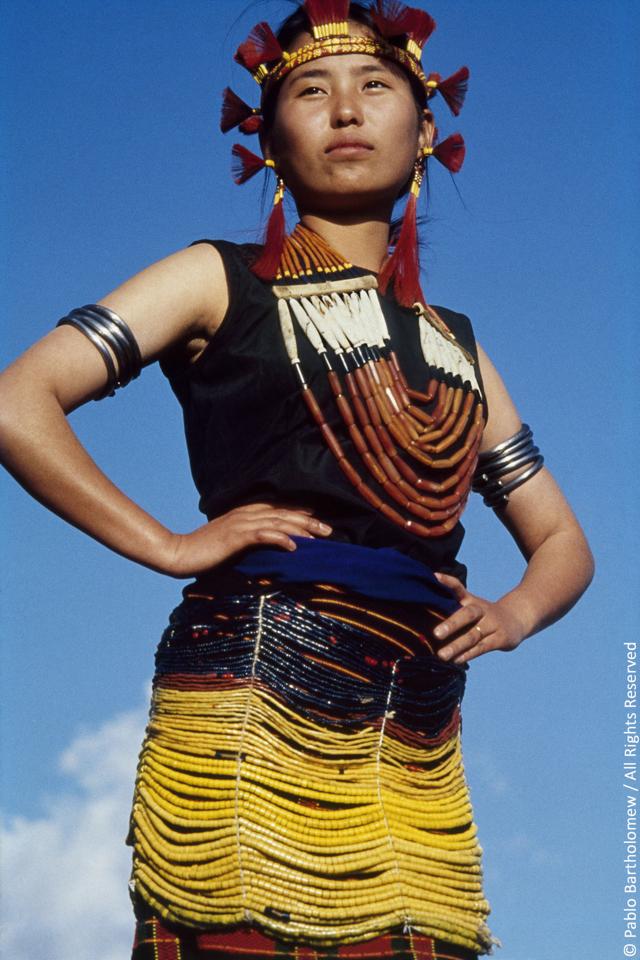 A young Sema girl in a beaded overskirt indicating her status as a member of a wealthy and influential family. Zuneboto District, Nagaland. (PABLO BARTHOLOMEW)