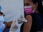 A healthcare worker inoculates a woman with a Covid-19 vaccine