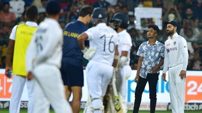 Virat Kohli poses for a photograph with a pitch invade (PTI)