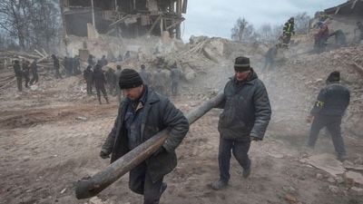 People remove debris at the site of a military base building that, according to the Ukrainian ground forces, was destroyed by an air strike, in the town of Okhtyrka in the Sumy region. (via Reuters/ Representative Image)
