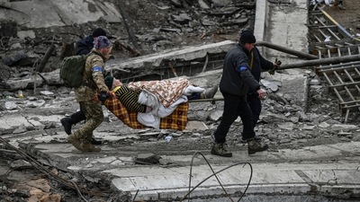 Ukrainian servicemen evacuate an elderly woman on a stretcher from the city of Irpin on March 13, 2022. - Russian forces advance ever closer to the capital from the north, west and northeast. (AFP) Ukrainian servicemen evacuate an elderly woman on a stretcher from the city of Irpin on March 13, 2022. - Russian forces advance ever closer to the capital from the north, west and northeast. (AFP)