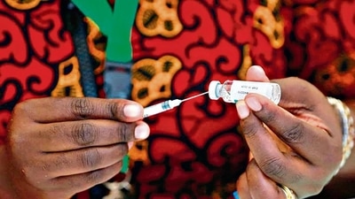 A health worker takes a dose of the COVID-19 vaccine from a vial during the roll out of mass vaccination in Abuja. (Reuters)