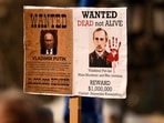 People hold a "Wanted" poster, showing Russian President Vladimir Putin during an anti-war demonstration, against Russia's invasion of Ukraine, in Frankfurt, Germany.