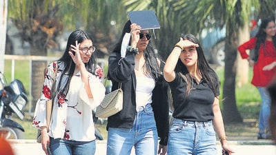 A group of girls seek shade amid rising temperatures at Panjab University in Chandigarh on Monday. (Ravi Kumar/HT)