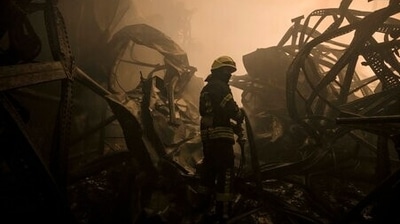 A Ukrainian firefighter drags a hose inside a large food products storage facility which was destroyed by an airstrike in the early morning hours on the outskirts of Kyiv, (AP Photo/Vadim Ghirda) (AP) A Ukrainian firefighter drags a hose inside a large food products storage facility which was destroyed by an airstrike in the early morning hours on the outskirts of Kyiv, (AP Photo/Vadim Ghirda) (AP)