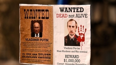 People hold a "Wanted" poster, showing Russian President Vladimir Putin during an anti-war demonstration, against Russia's invasion of Ukraine, in Frankfurt, Germany. (Reuters)