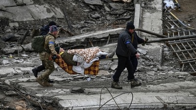 Ukrainian servicemen evacuate an elderly woman on a stretcher from the city of Irpin on Sunday. (AFP) Ukrainian servicemen evacuate an elderly woman on a stretcher from the city of Irpin on Sunday. (AFP)