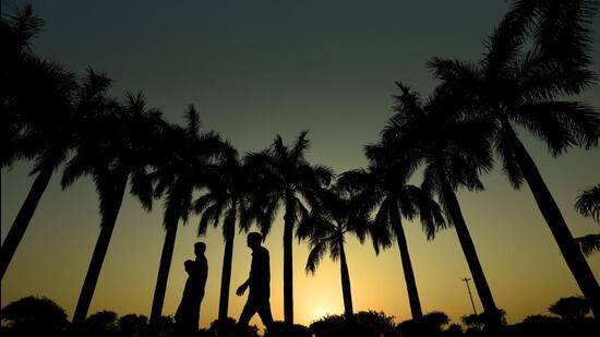 Pedestrians during sunset at Indraprastha Park in New Delhi, on Monday. (Raj K Raj/HT)