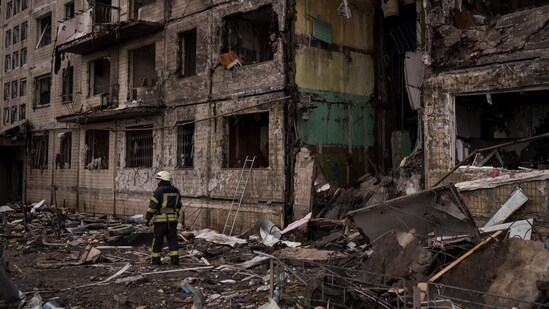 A Ukrainian firefighter stands outside a destroyed building after it was hit by artillery shelling in Kyiv, Ukraine.(AP)