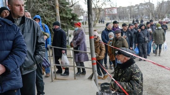 People line up for a food distribution in front of a supermarket in Mykolaiv, Ukraine.(AFP)