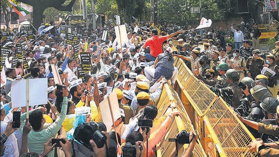 Paramilitary and police personnel keep AAP supporters from marching towards the BJP HQ on Monday. (Amal KS/HT)