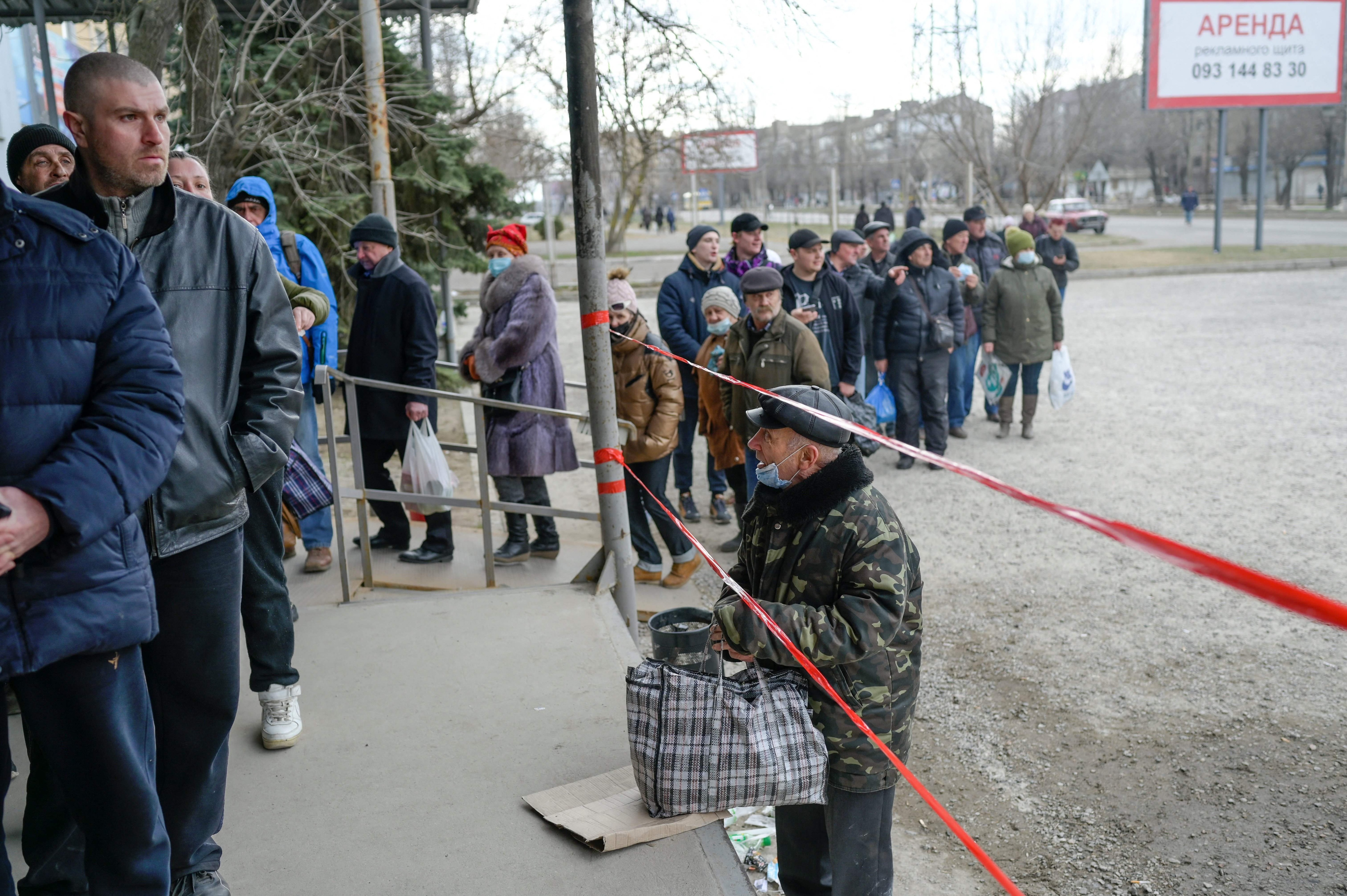 People line up for a food distribution in front of a supermarket in Mykolaiv, Ukraine. (AFP)