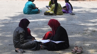 Students sit and study in the playground of a college in Bangalore on March 15, 2022, after an Indian court upheld a local ban on the hijab in classrooms, weeks after the edict stoked violent protests and renewed fears of discrimination against the country's Muslim minority. (Photo by Manjunath Kiran / AFP) (AFP) Students sit and study in the playground of a college in Bangalore on March 15, 2022, after an Indian court upheld a local ban on the hijab in classrooms, weeks after the edict stoked violent protests and renewed fears of discrimination against the country's Muslim minority. (Photo by Manjunath Kiran / AFP) (AFP)