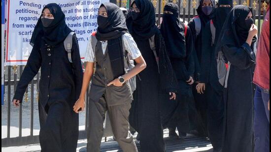 Students walk back home after being denied entry with hijab at a college in Shivamogga on February 28. (PTI Photo)