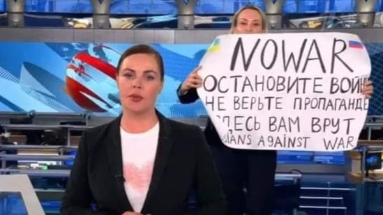 As video grab taken on March 15 showing Russian Channel One editor Marina Ovsyannikova holding a poster reading ‘Stop the war…’.(AFP)