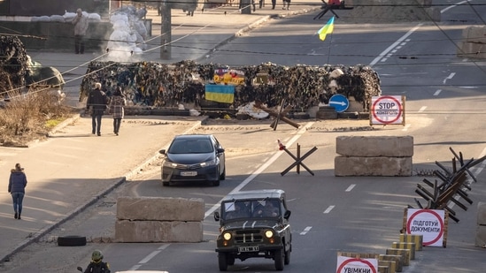 A car rides away from a Ukrainian military check point in the center of Kyiv.(AFP)