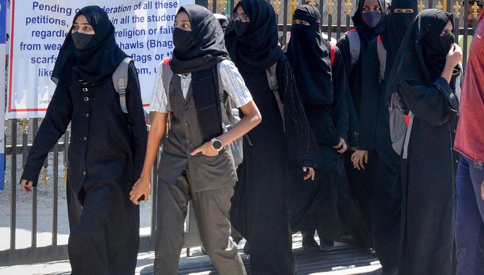 Students walk back home after being denied entry with hijab at a college in Shivamogga on February 28. (PTI) Students walk back home after being denied entry with hijab at a college in Shivamogga on February 28. (PTI)
