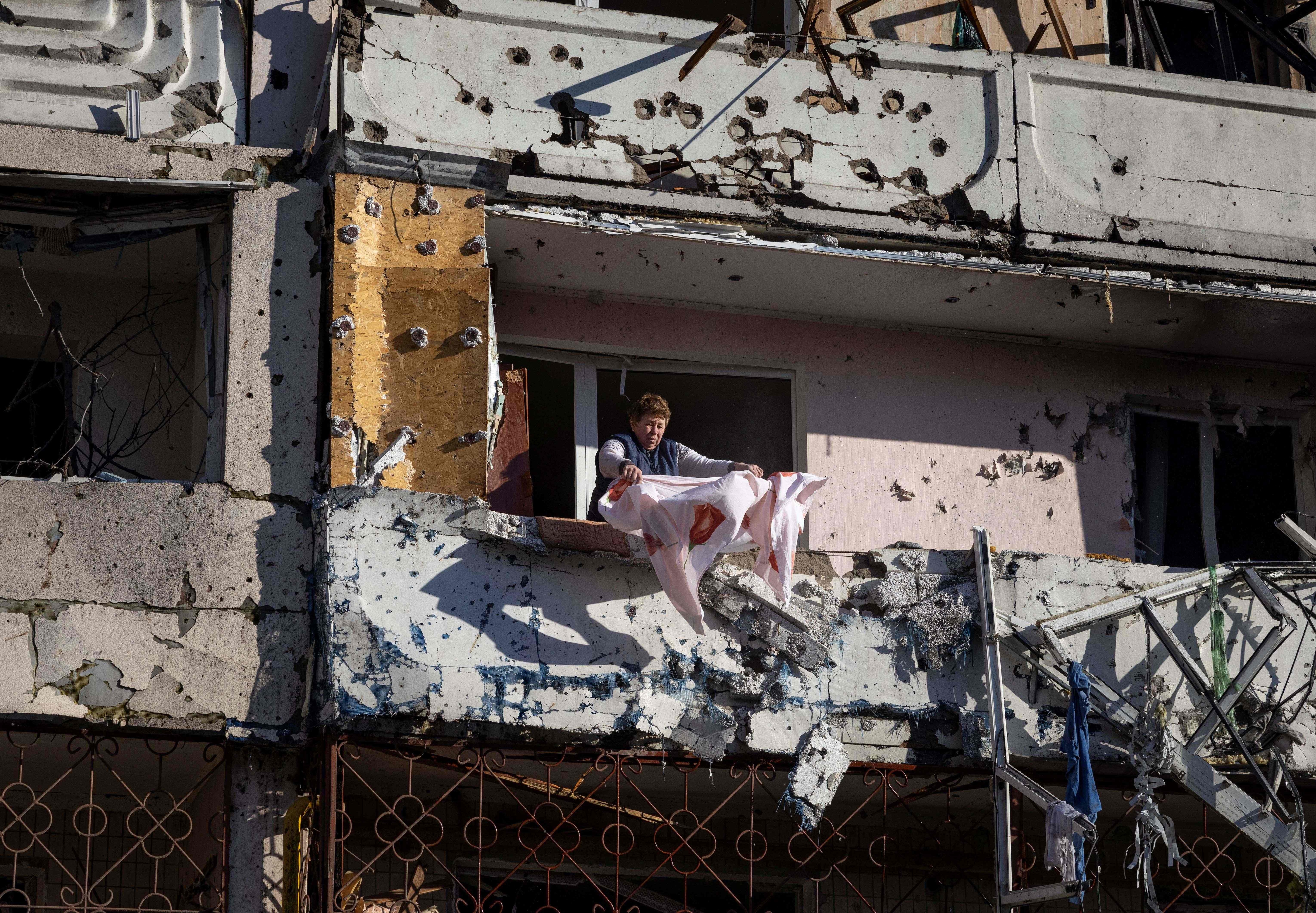 A resident cleans her balcony in a residential building damaged by shelling in Kyiv. (AFP) A resident cleans her balcony in a residential building damaged by shelling in Kyiv. (AFP)