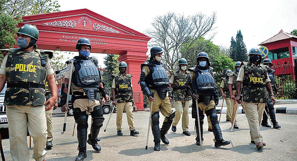 Police personnel patrolling in front of Karnataka High Court following the verdict of Hijab issue, in Bengaluru on Tuesday. Karnataka High Court upheld the hijab ban in schools and colleges, saying that wearing the hijab is not essential to Islam. (ANI Photo)