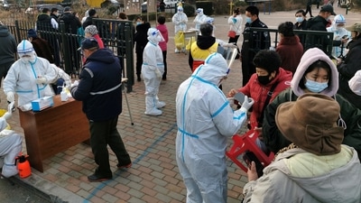 Residents line up at a nucleic acid testing site during a mass testing for the coronavirus disease (Covid-19), at a residential compound in Dalian, Liaoning province, China. (VIA REUTERS)