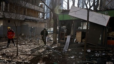 A resident walks through debris next to a building that was hit by shelling, as Russia's attack on Ukraine continues, in Kyiv. (REUTERS)