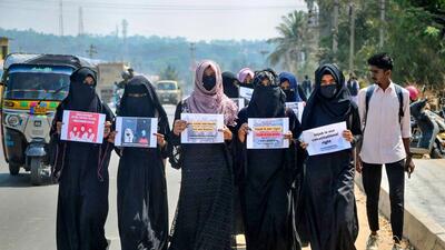 Muslim students wearing burqa protest against the Karnataka high court's verdict on hijab by boycotting their internal exams in front of IDSG college in Chikmagalur on Wednesday. (PTI) Muslim students wearing burqa protest against the Karnataka high court's verdict on hijab by boycotting their internal exams in front of IDSG college in Chikmagalur on Wednesday. (PTI)