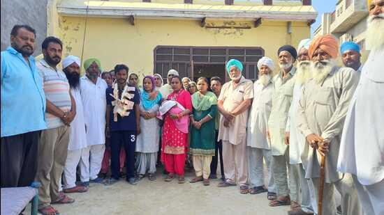 Residents of Faridkot’s Sher Singh Wala village with the family of daily wage worker Jaswinder Singh (garlanded), who were reunited after seven years, after he was found making preparations for the swearing-in ceremony of Bhagwant Mann as Punjab’s chief minister. (HT Photo)