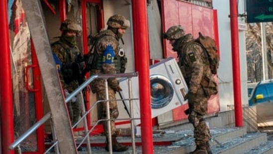 Ukrainian servicemen carry a washing machine as they help to relocate goods from a market that was destroyed by shelling in Kharkiv on March 15, 2022. (AP file photo) Ukrainian servicemen carry a washing machine as they help to relocate goods from a market that was destroyed by shelling in Kharkiv on March 15, 2022. 