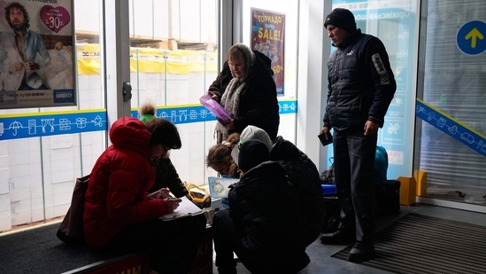 Evacuees from Mariupol are seen at a shopping centre on the outskirts of the city of Zaporizhzhia, which is now a registration centre for displaced people, on March 16, 2022. (Photo by Emre CAYLAK/AFP)