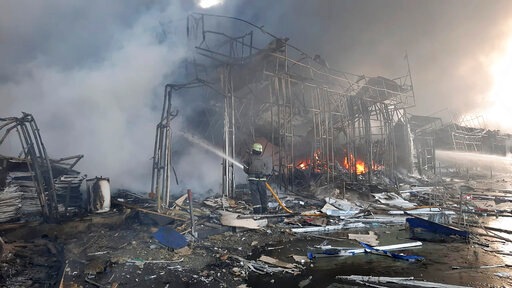 Firefighters work to extinguish a fire at a market hit by shelling in Kharkiv, Ukraine, Wednesday. (AP)