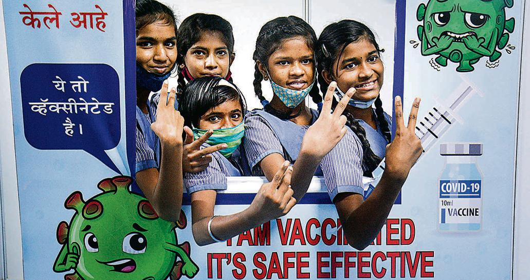 Students pose for photos after receiving a dose of Covid-19 vaccine at a vaccination centre in a parking plaza, in Thane, Wednesday, March 16, 2022. (PTI Photo) Students pose for photos after receiving a dose of Covid-19 vaccine at a vaccination centre in a parking plaza, in Thane, Wednesday, March 16, 2022. (PTI Photo)