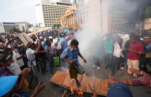 Supporter of Sri Lanka's main opposition burn placards and a coffin during a protest outside the president's office in Colombo, Sri Lanka, Tuesday, March 15, 2022. (AP Photo/Eranga Jayawardena) Supporter of Sri Lanka's main opposition burn placards and a coffin during a protest outside the president's office in Colombo, Sri Lanka, Tuesday, March 15, 2022. (AP Photo/Eranga Jayawardena)