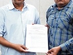 Delhi Chief Minister Arvind Kejriwal hands over a government job appointment letter to Ankur Sharma, brother of IB employee Ankit Sharma, who lost his life in Delhi violence, in New Delhi.