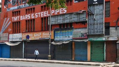 A man walks past closed shops being run by Muslim people as they protest against Karnataka's high court decision to upheld a local ban on the hijab in classrooms, in Bangalore. (AFP) A man walks past closed shops being run by Muslim people as they protest against Karnataka's high court decision to upheld a local ban on the hijab in classrooms, in Bangalore. (AFP)