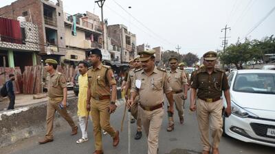 ACP Rajneesh along with other police personnel participate in a flag march on the eve of Holi festival at Sector 5 in Noida, on Thursday. (Sunil Ghosh/ HT)