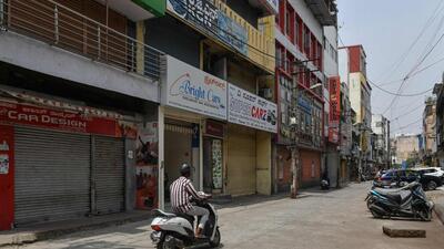 Commuters drive past closed shops run by Muslim people as they protest against Karnataka's high court decision to upheld a local ban on the hijab in classrooms, in Bangalore. (AFP) Commuters drive past closed shops run by Muslim people as they protest against Karnataka's high court decision to upheld a local ban on the hijab in classrooms, in Bangalore. (AFP)