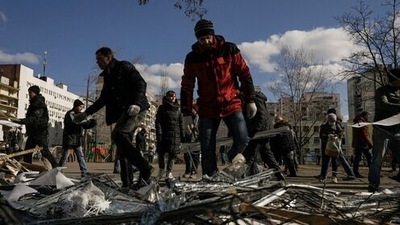 People clear debris outside a medical center damaged after parts of a Russian missile, shot down by Ukrainian air defense, landed on a nearby apartment block, according to authorities, in Kyiv, Ukraine, Thursday. (AP)