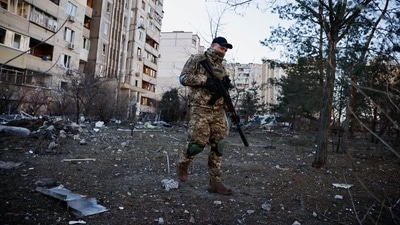 A member of the Ukrainian military surveys an area next to a residential building hit by an intercepted missile, as Russia's invasion of Ukraine continues, in Kyiv, Ukraine March 17, 2022. REUTERS/Thomas Peter (REUTERS)