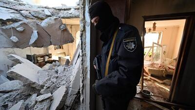 A police officer stands inside a destroyed apartment at a damaged housing block after it was hit by debris from a downed rocket in Kyiv on Thursday. (AFP) A police officer stands inside a destroyed apartment at a damaged housing block after it was hit by debris from a downed rocket in Kyiv on Thursday. (AFP)