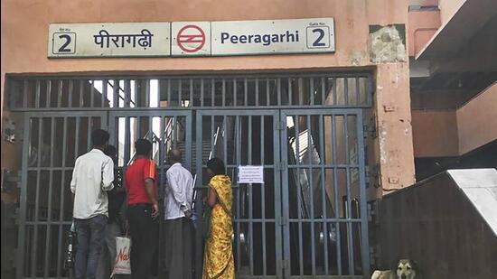 Commuters wait outside the closed Peeragarhi Metro station, after services were delayed on three corridors of the Delhi Metro due to a technical glitch in New Delhi on Thursday. (PTI)