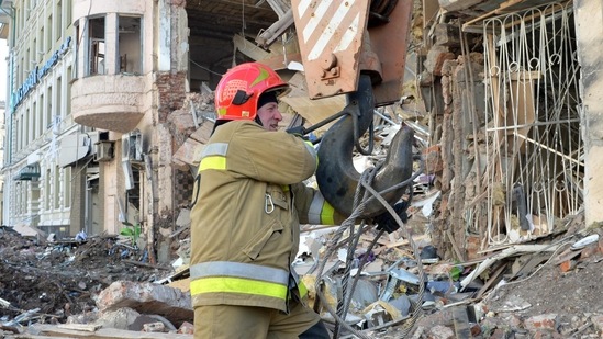Rescuers remove debris from a building damaged by shelling in central Kharkiv on March 16, 2022,