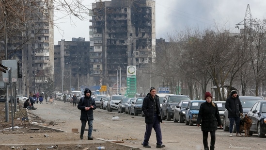 A view shows people and a line of cars near blocks of flats destroyed during Ukraine-Russia conflict, as evacuees leave the besieged southern port city of Mariupol.(REUTERS)