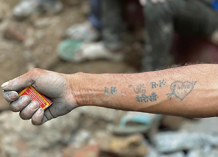 Khajani shows his tattooed arm. Khajani shows his tattooed arm.