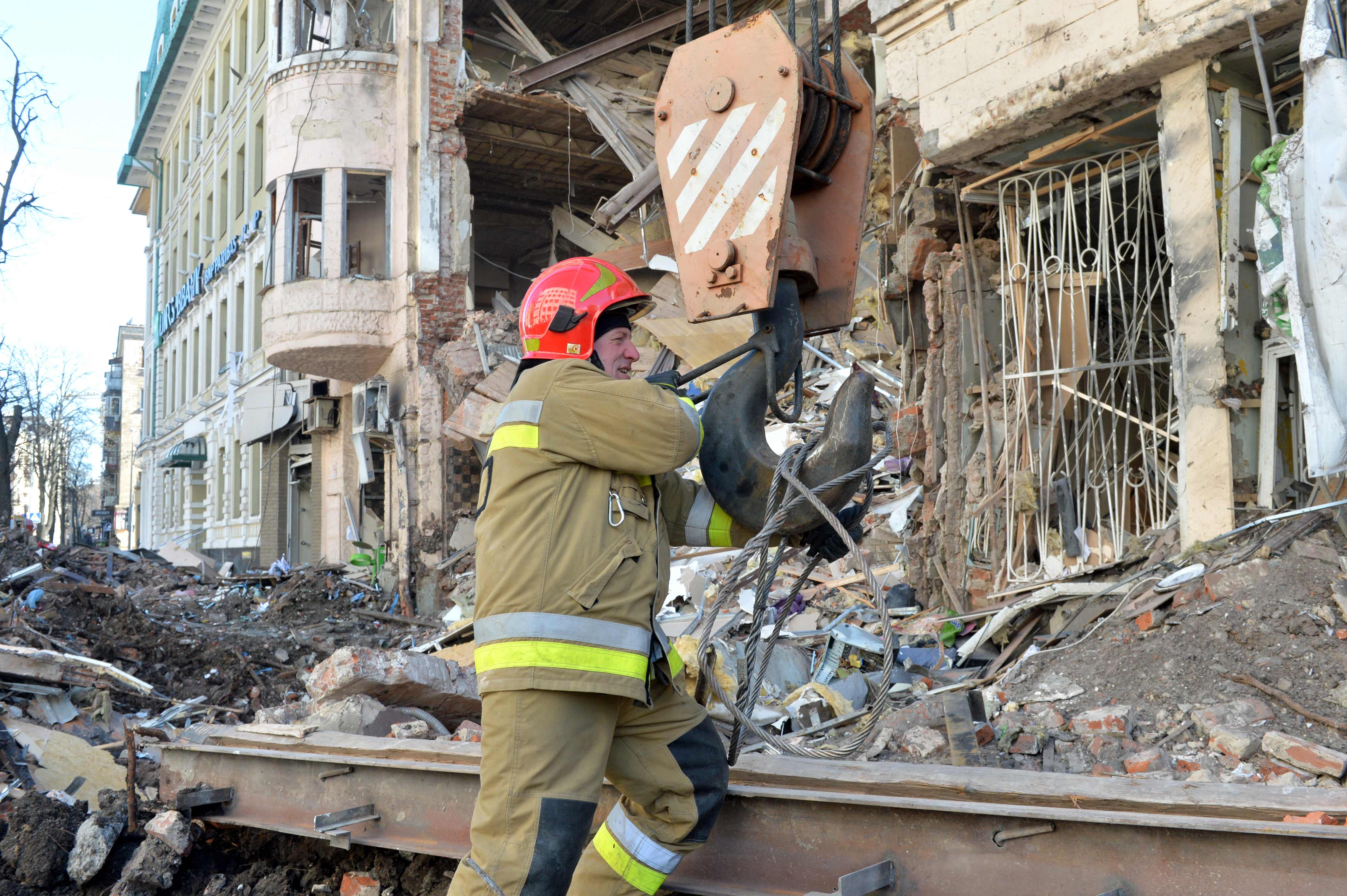 Rescuers remove debris from a building damaged by shelling in central Kharkiv on March 16, 2022, (AFP)