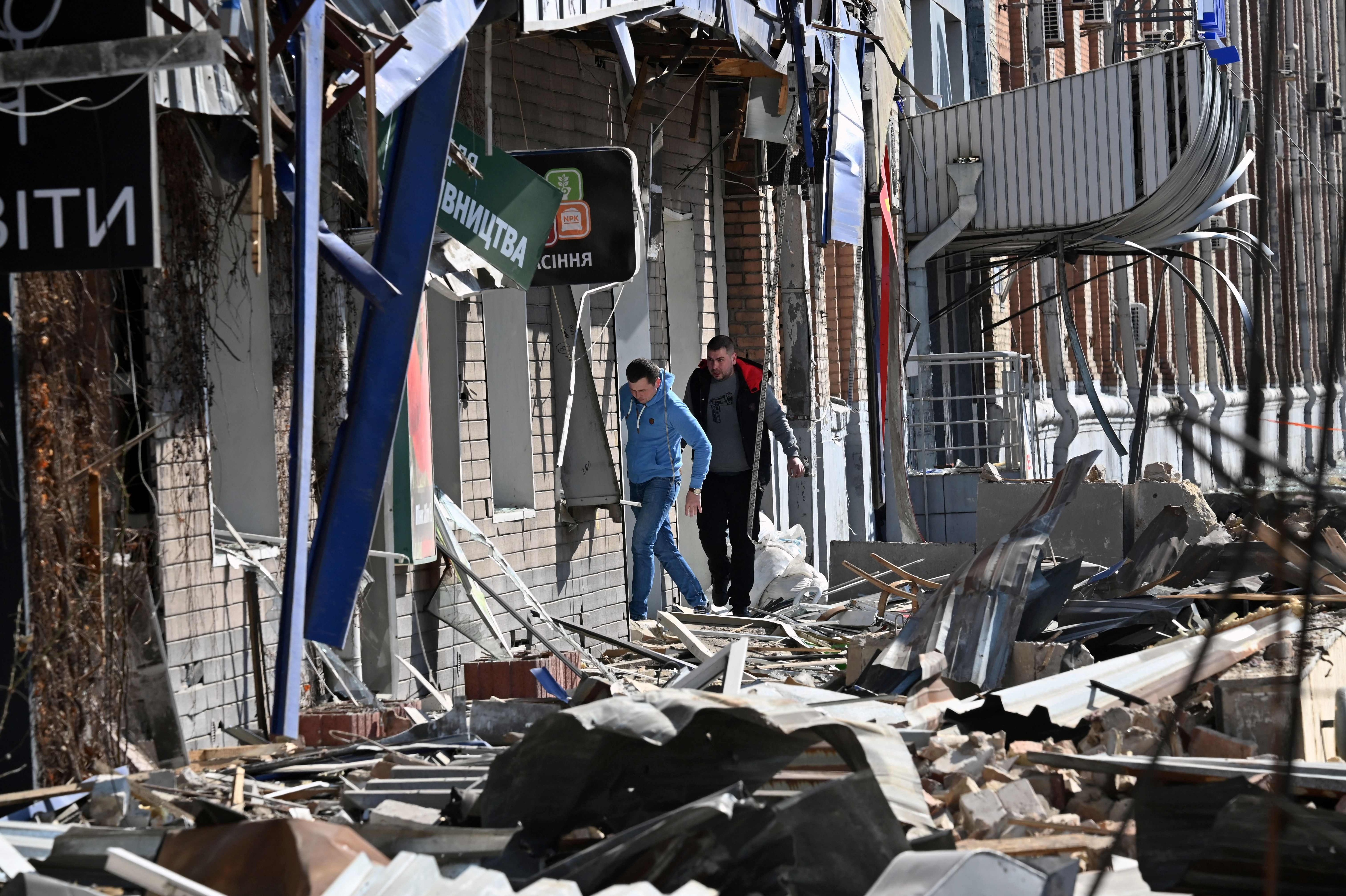 People walk by a building damaged by shelling amid Russian invasion of Ukraine in Kyiv on March 17, 2022.&nbsp; (AFP Photo)