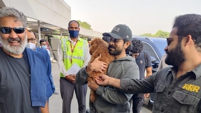 The team of RRR playing with Ram Charan's dog. The team of RRR playing with Ram Charan's dog.